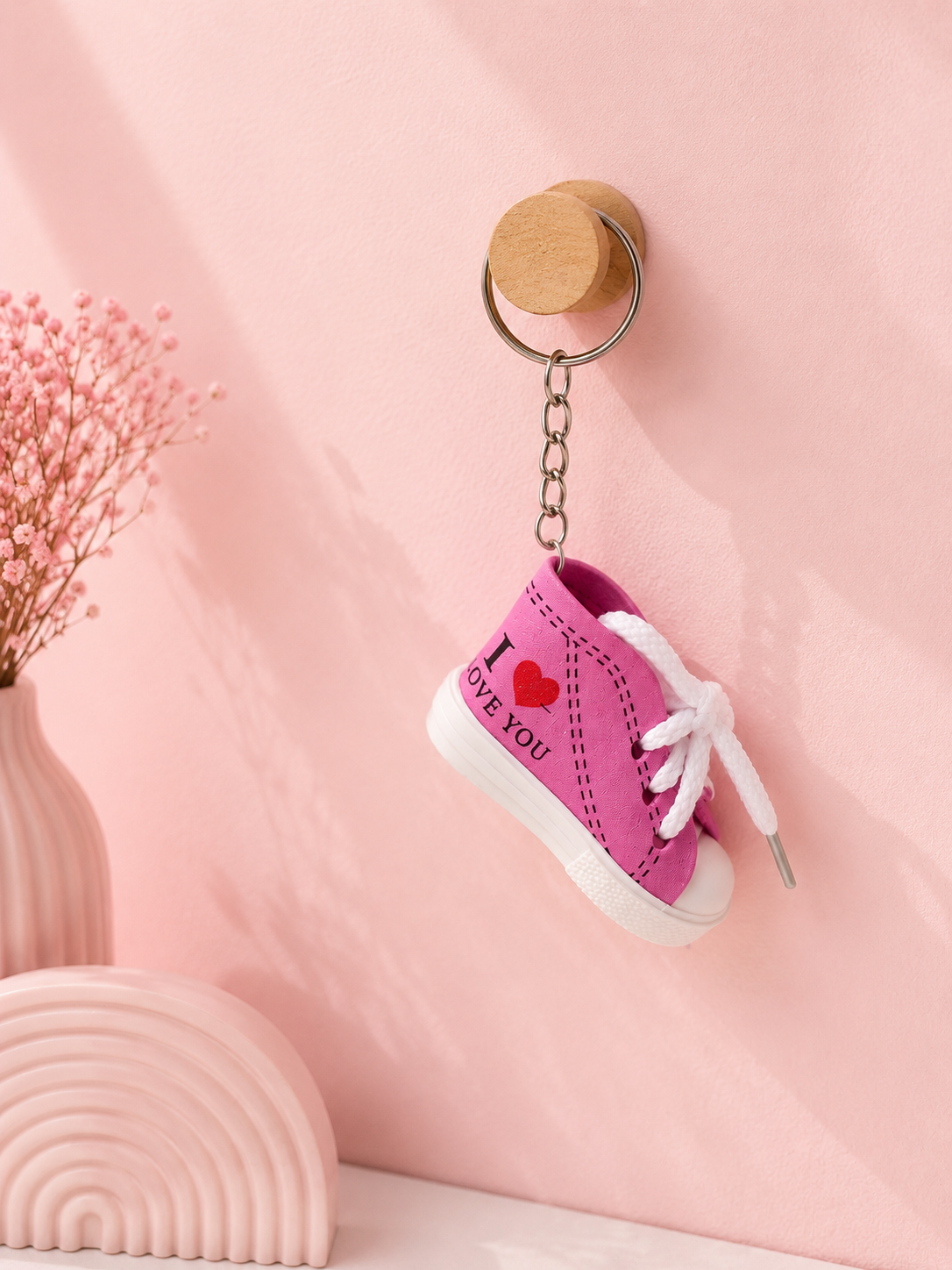 Magenta sneaker keychain with metal key ring, chain, and white sole with laces