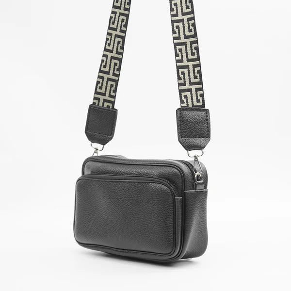 Black shoulder bag front view with dual zippers and adjustable Greek-key strap
