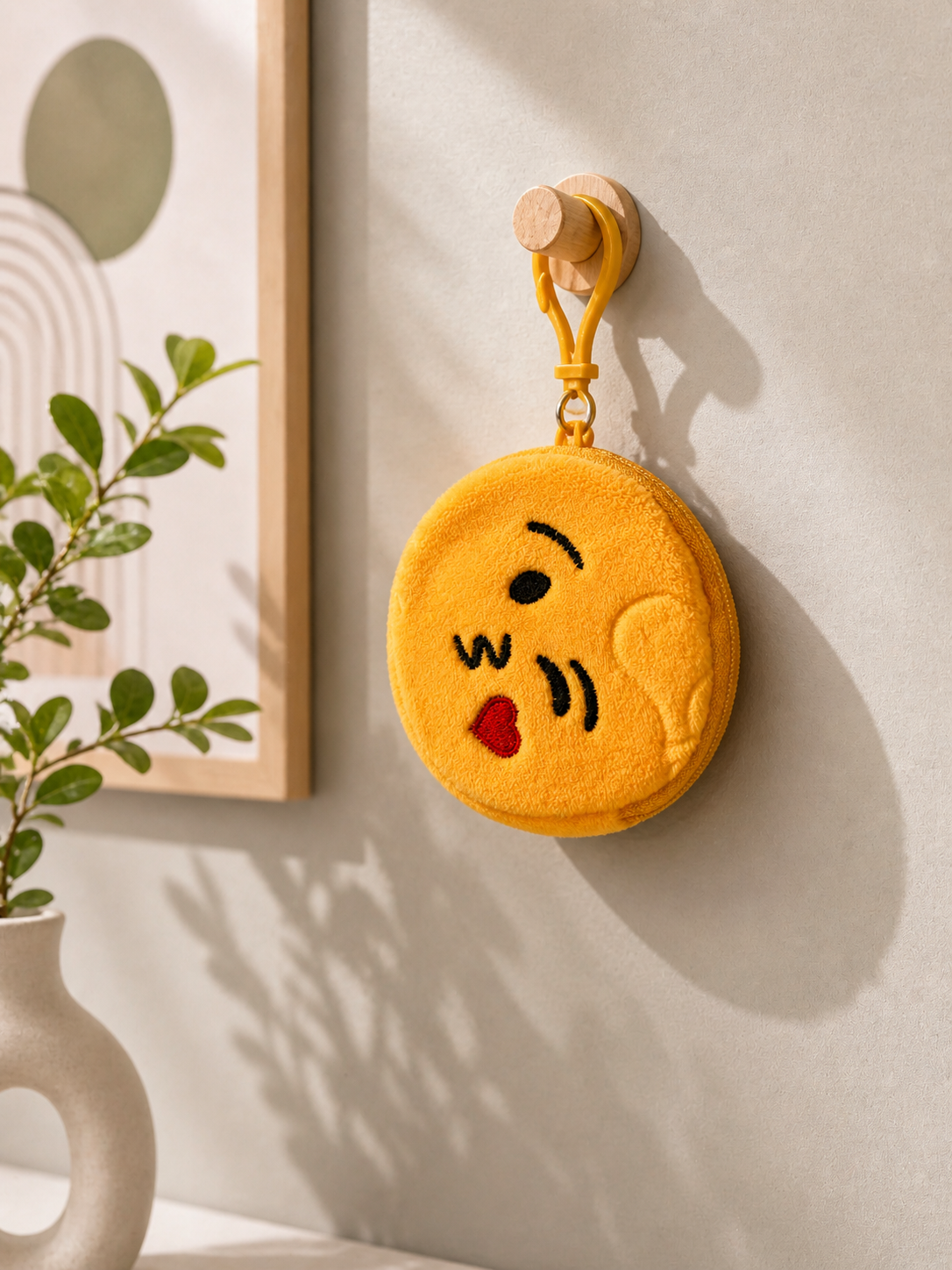 Plush emoji pouch keychain with yellow face and red heart detail