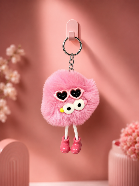 Pink fluffy bear keychain with heart-shaped eyes, small yellow nose, pink shoes