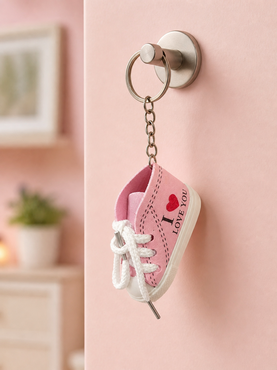 Soft pink sneaker keychain with white laces and metal keyring