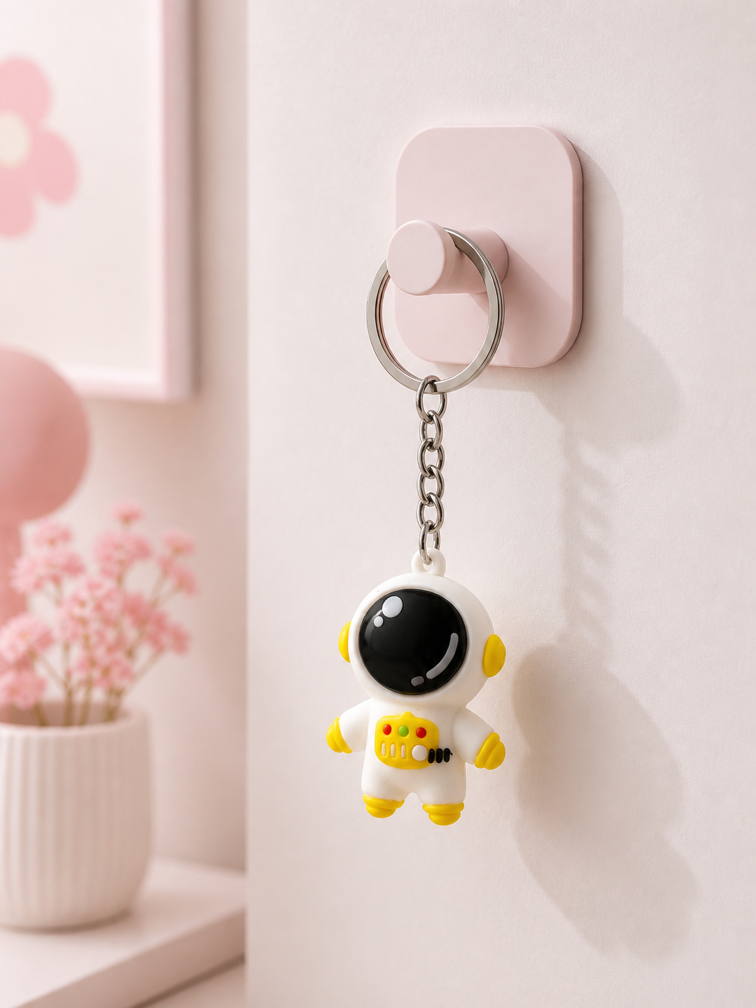 Astronaut keychain with yellow accents, black helmet, and silver chain ring