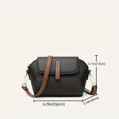 Dark mini crossbody handbag with front flap and brown shoulder strap, compact size