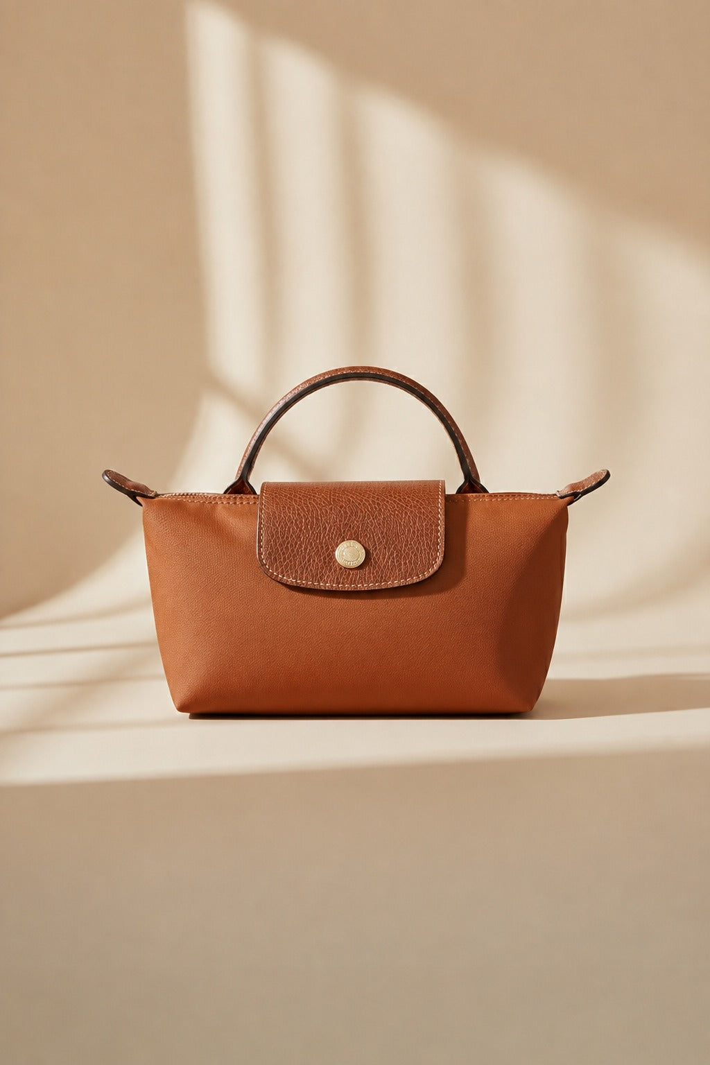 Brown mini crossbody bag with top handles and front flap pocket