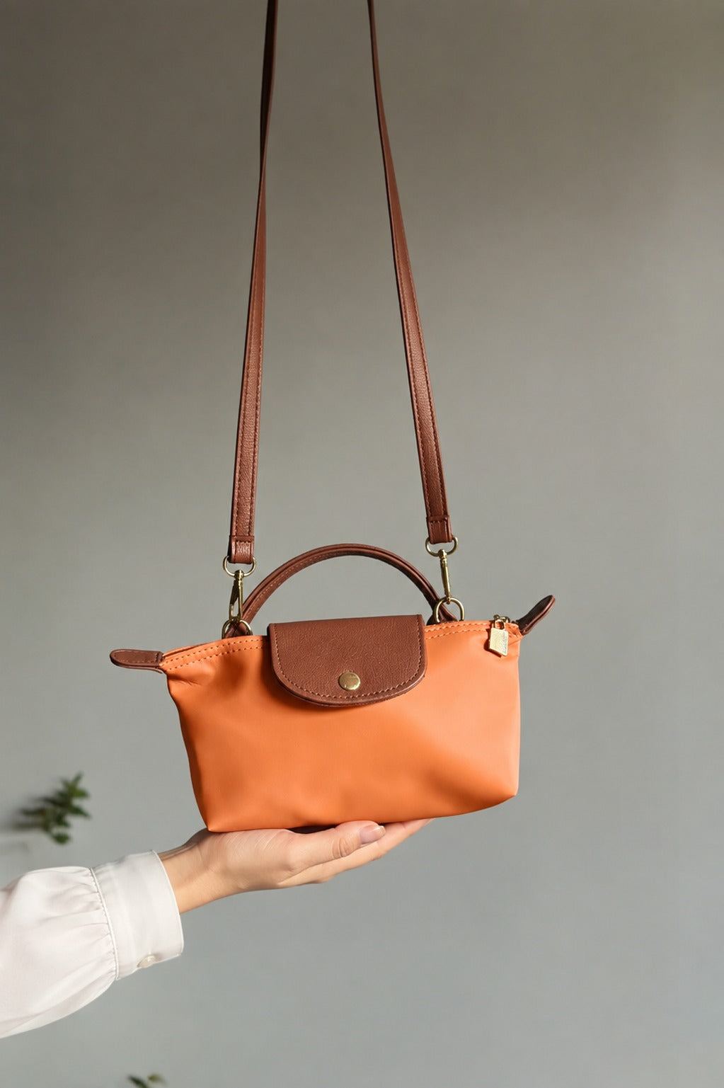 Brown crossbody bag with long adjustable strap and snap front flap pocket