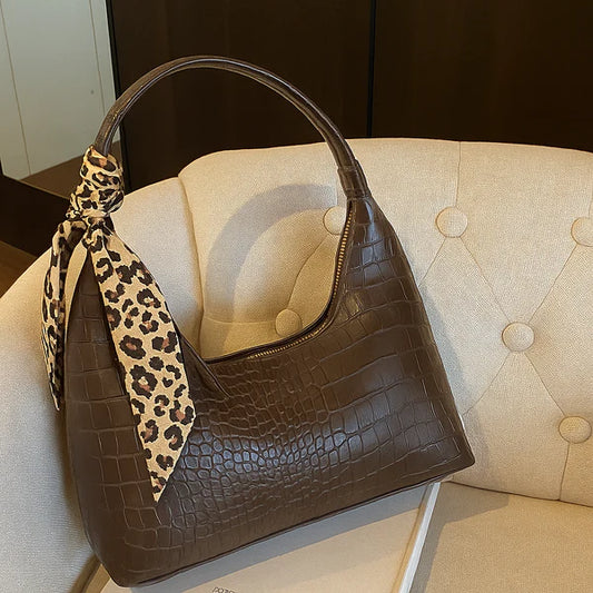 Brown croc-effect shoulder bag with leopard print strap and top zip pocket